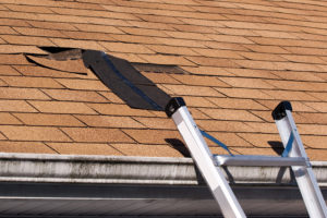 Fixing damaged roof shingles. A section was blown off after a storm with high winds causing a potential leak.